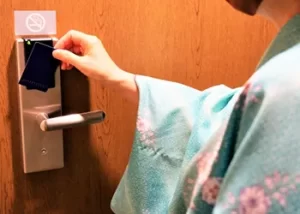 カードリーダーにカードキーをかざす女性